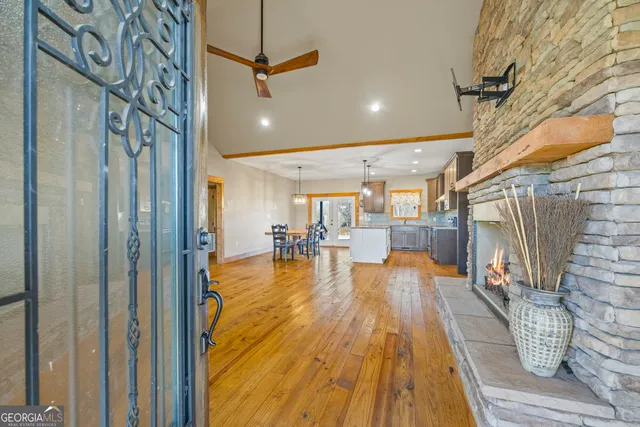 a large kitchen with stainless steel appliances kitchen island granite countertop a table chairs and a chandelier