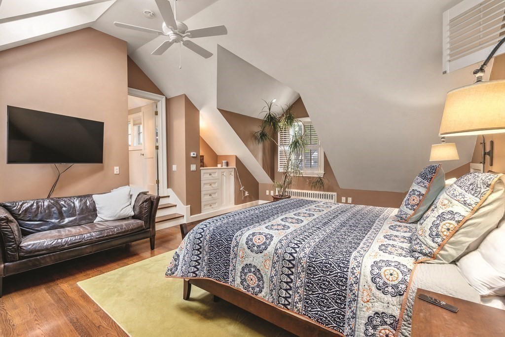 131 Oliver Road Newton, MA 02468 - Photo 22 of 41 a spacious bedroom with a bed couch and a flat screen tv