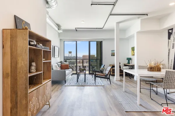 a living room with furniture a large window and stainless steel appliances