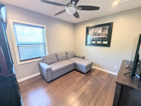 a view of a patio with table and chairs potted plants and floor to ceiling window