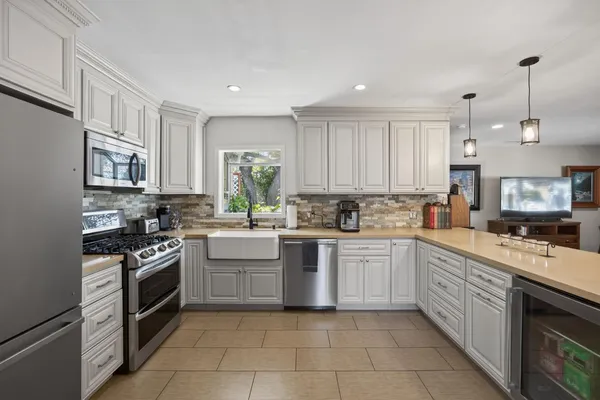 a view of a patio with a table and chairs and a barbeque