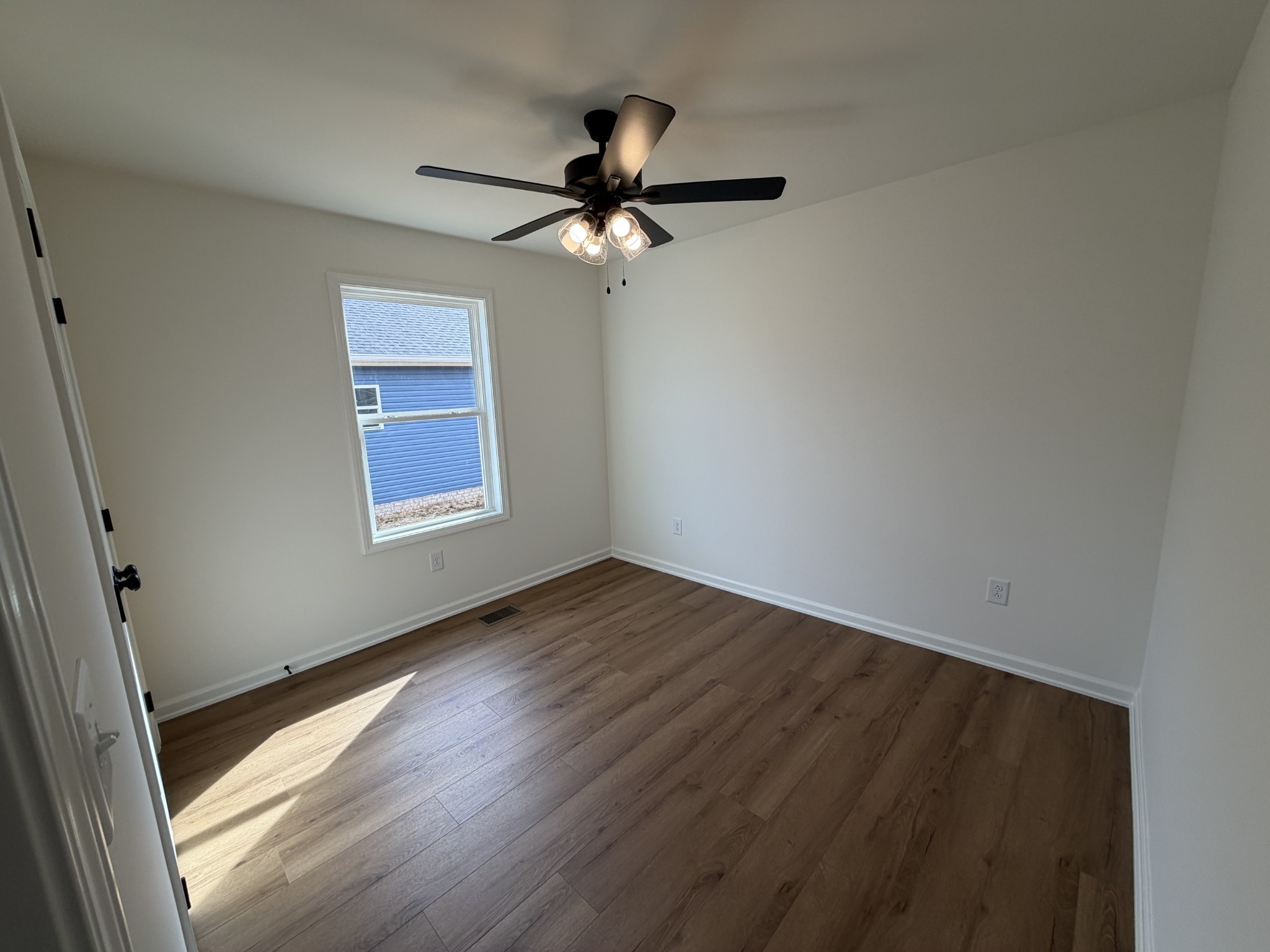 408 Church Street Portland, TN 37148 - Photo 11 of 11 an empty room with wooden floor fan and windows