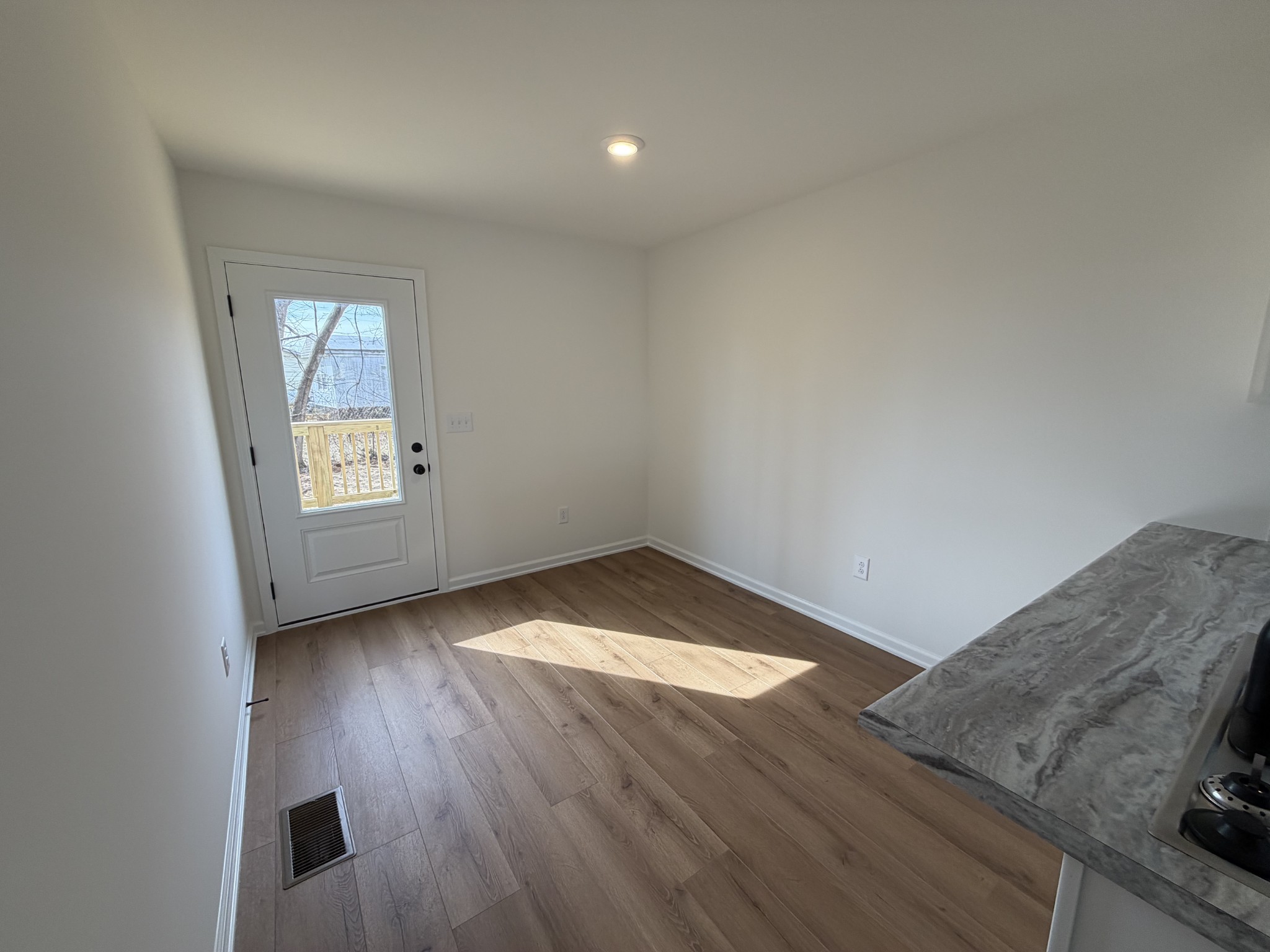 408 Church Street Portland, TN 37148 - Photo 6 of 11 an empty room with wooden floor cabinet and windows
