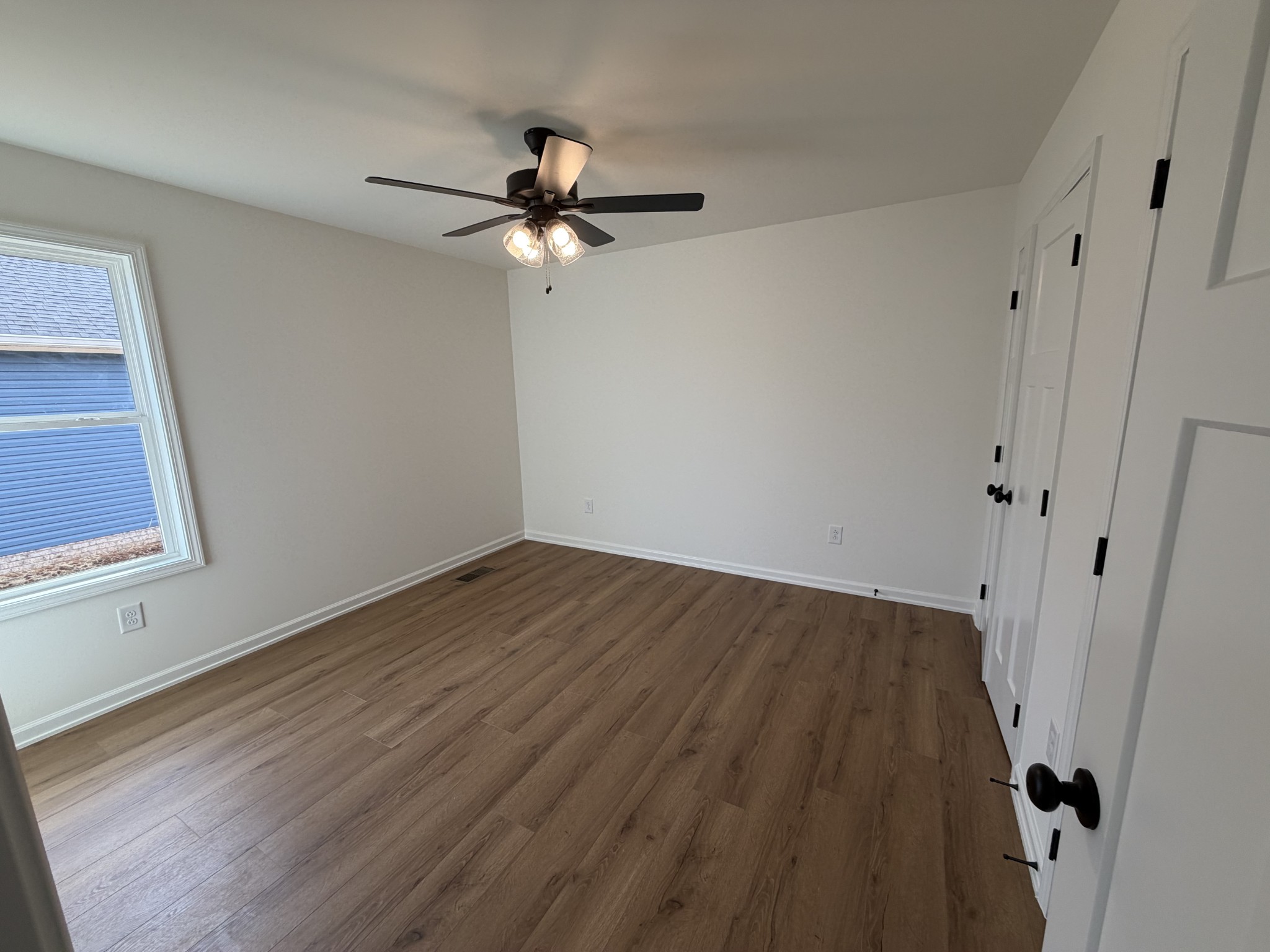 408 Church Street Portland, TN 37148 - Photo 7 of 11 an empty room with wooden floor fan and windows