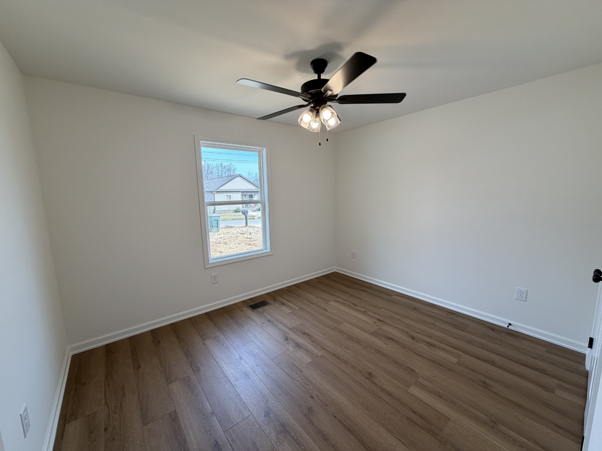 408 Church Street Portland, TN 37148 - Photo 9 of 11 a view of an empty room with wooden floor and a window