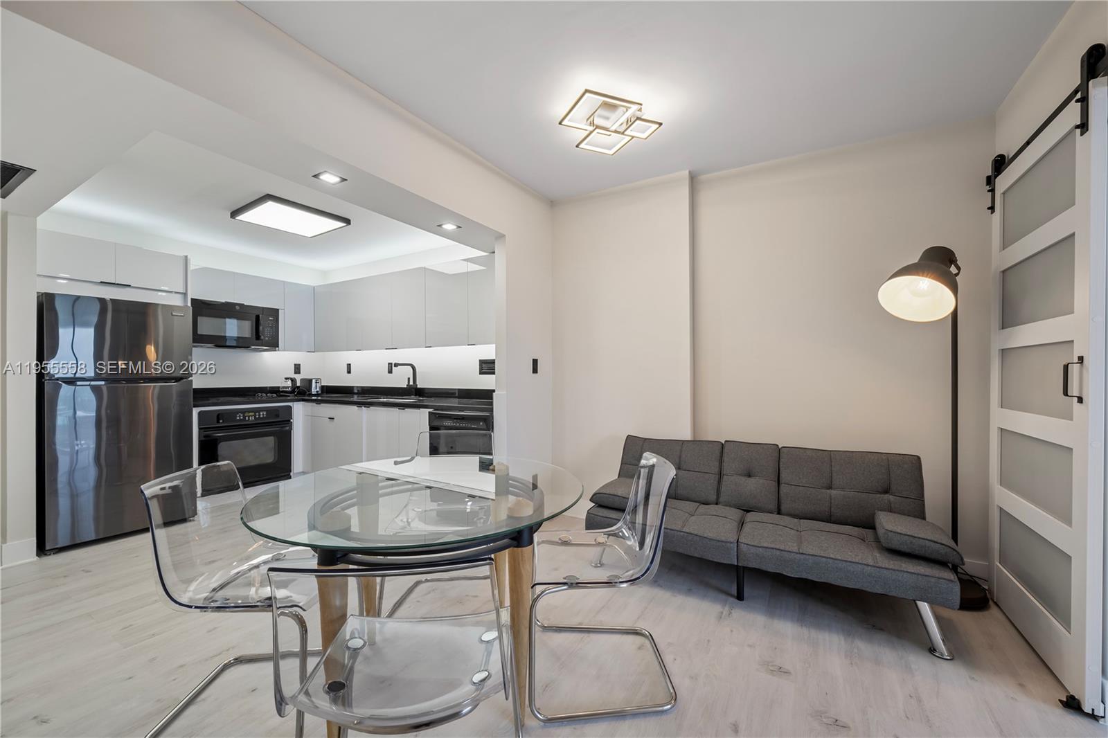 2301 Collins Avenue, Unit 1130 Miami Beach, FL 33139 - Photo 6 of 29 a living room with furniture a kitchen island and a chandelier