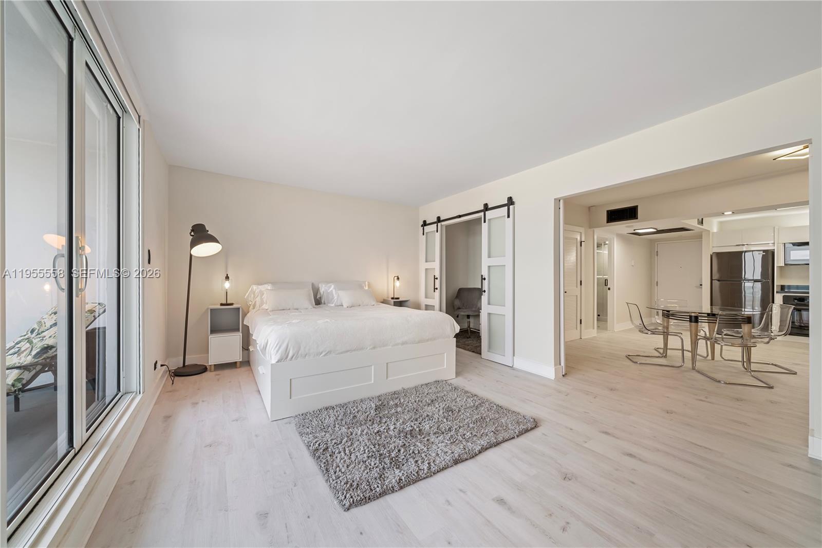 2301 Collins Avenue, Unit 1130 Miami Beach, FL 33139 - Photo 8 of 29 a spacious bedroom with a bed a mirror and a table