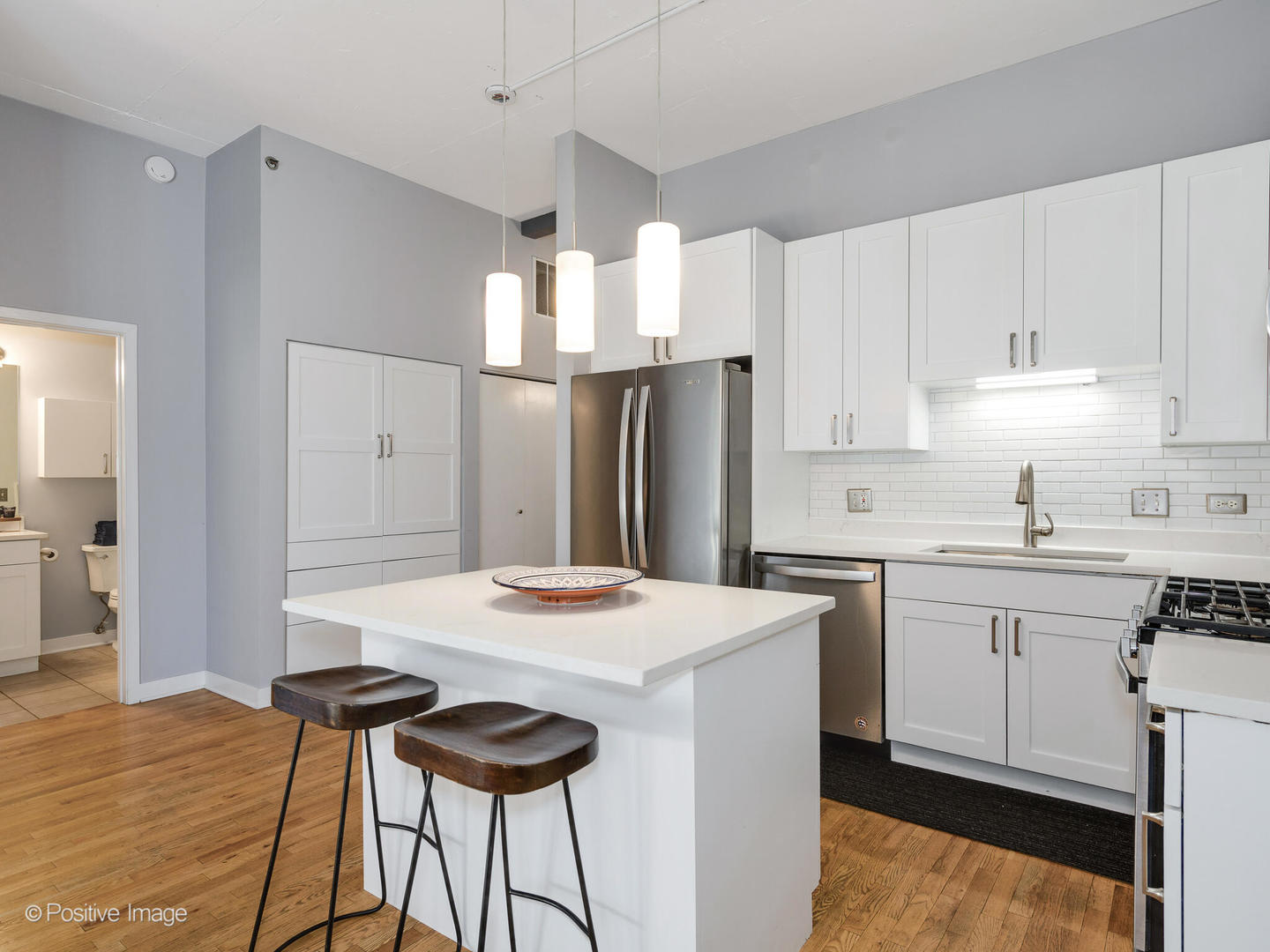 910 West Madison Street, Unit 509 Chicago, IL 60607 - Photo 7 of 14 a kitchen with stainless steel appliances kitchen island a table chairs in it white cabinets and a refrigerator