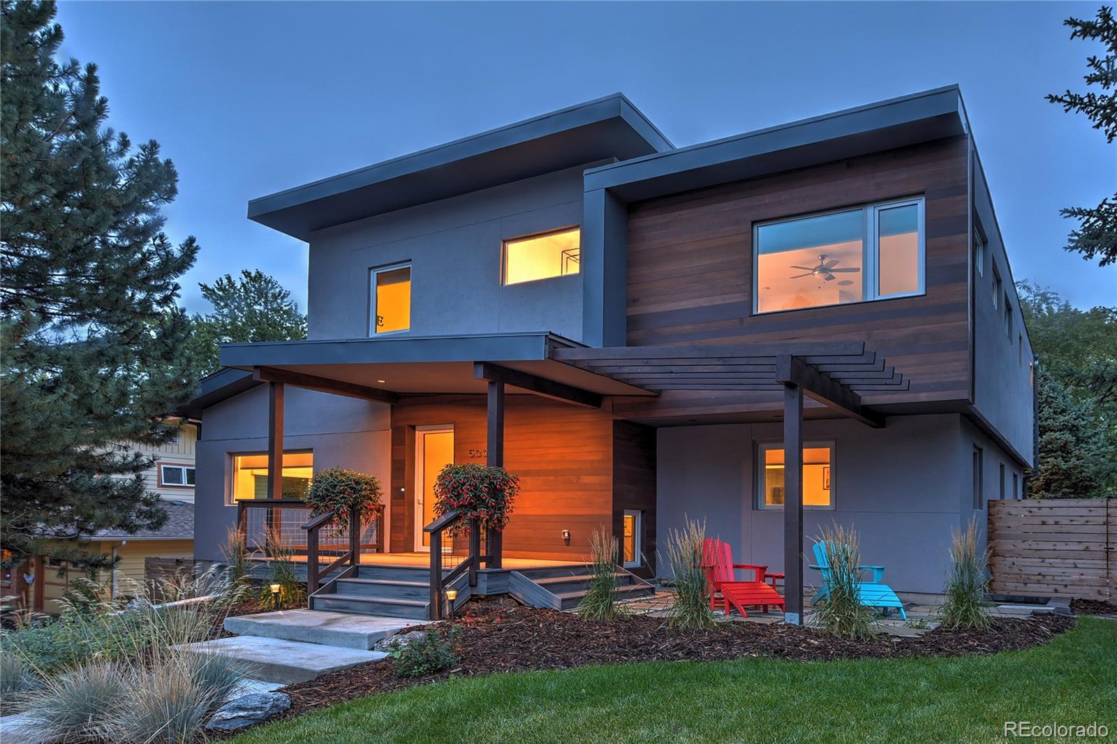 a view of a house with potted plants and a yard