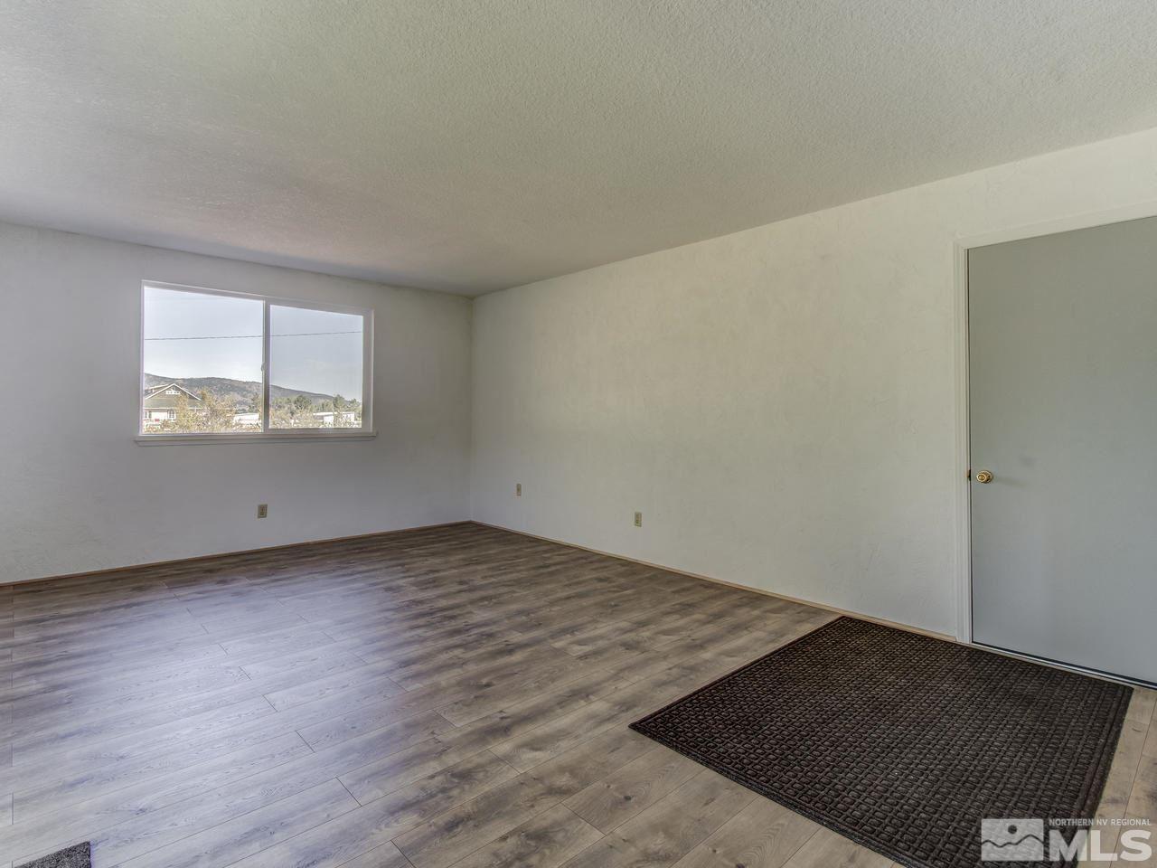 7465 Franktown Road Carson City, NV 89704 - Photo 14 of 25 an empty room with wooden floor and windows