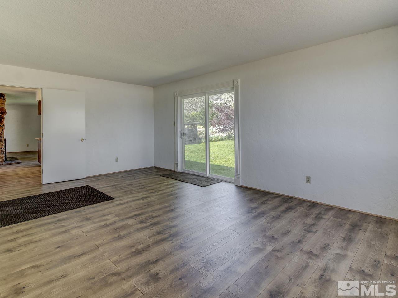 7465 Franktown Road Carson City, NV 89704 - Photo 15 of 25 an empty room with wooden floor and windows