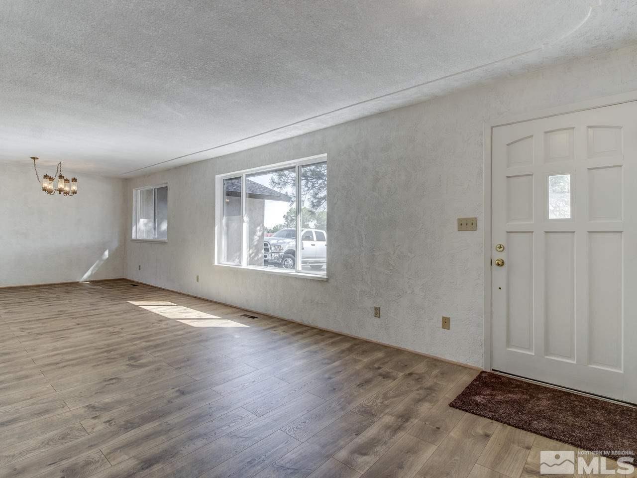 7465 Franktown Road Carson City, NV 89704 - Photo 2 of 25 an empty room with wooden floor cabinet and windows