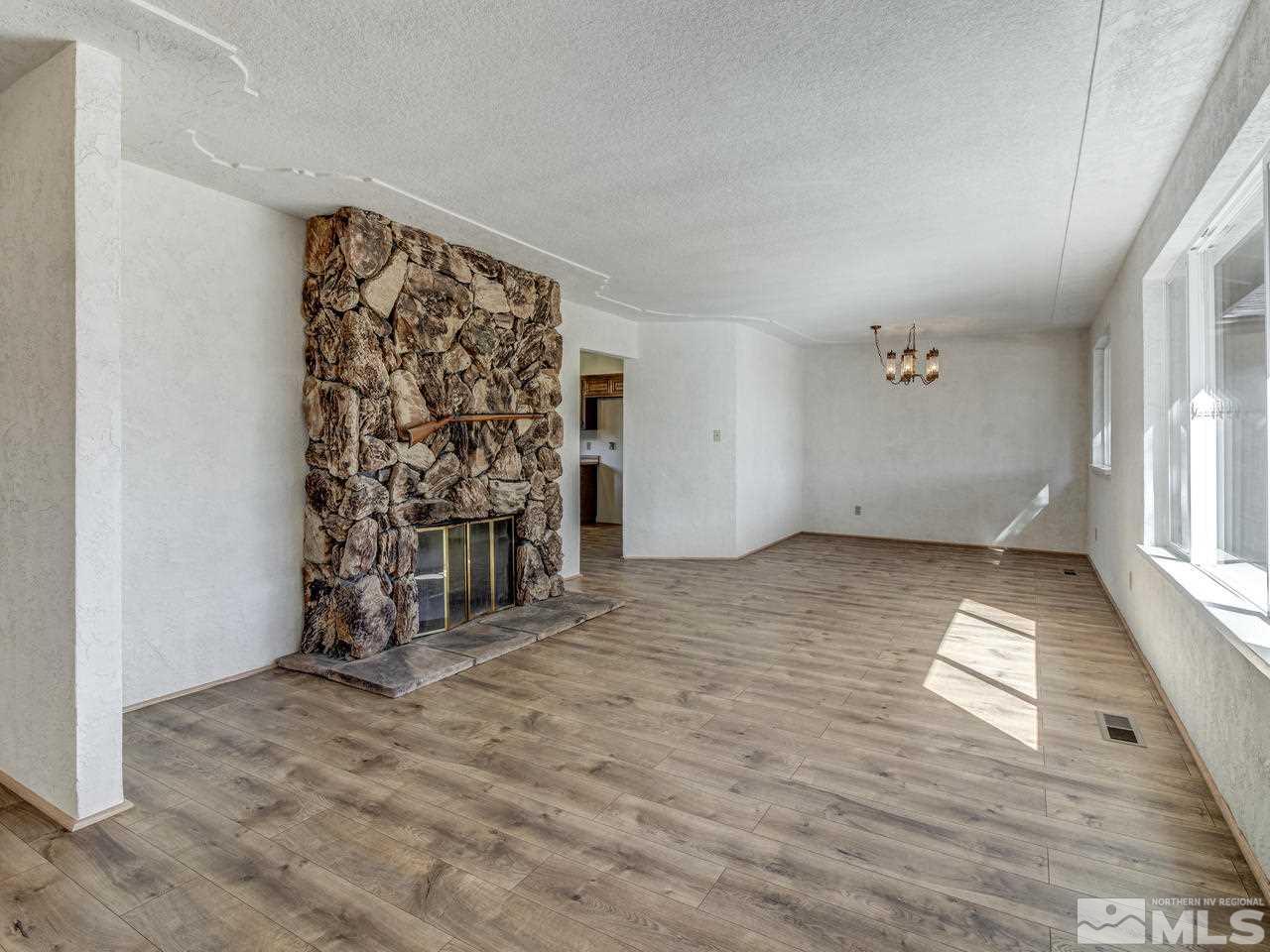 7465 Franktown Road Carson City, NV 89704 - Photo 3 of 25 an empty room with wooden floor and windows