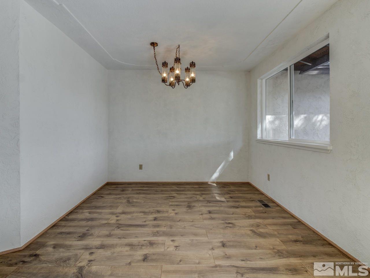 7465 Franktown Road Carson City, NV 89704 - Photo 5 of 25 a view of an empty room with wooden floor and a window