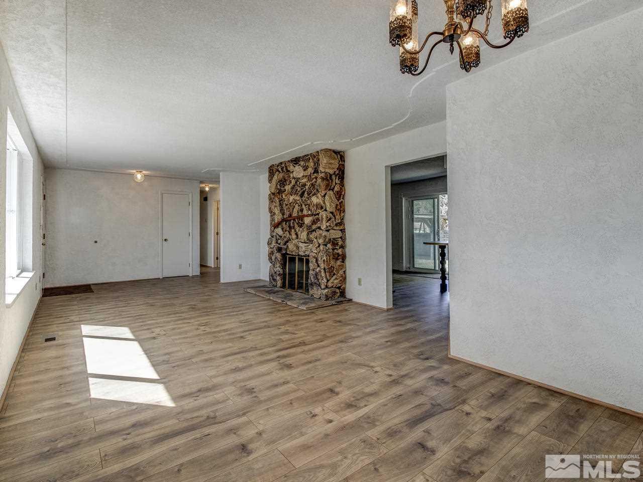 7465 Franktown Road Carson City, NV 89704 - Photo 6 of 25 an empty room with chandelier fan and windows