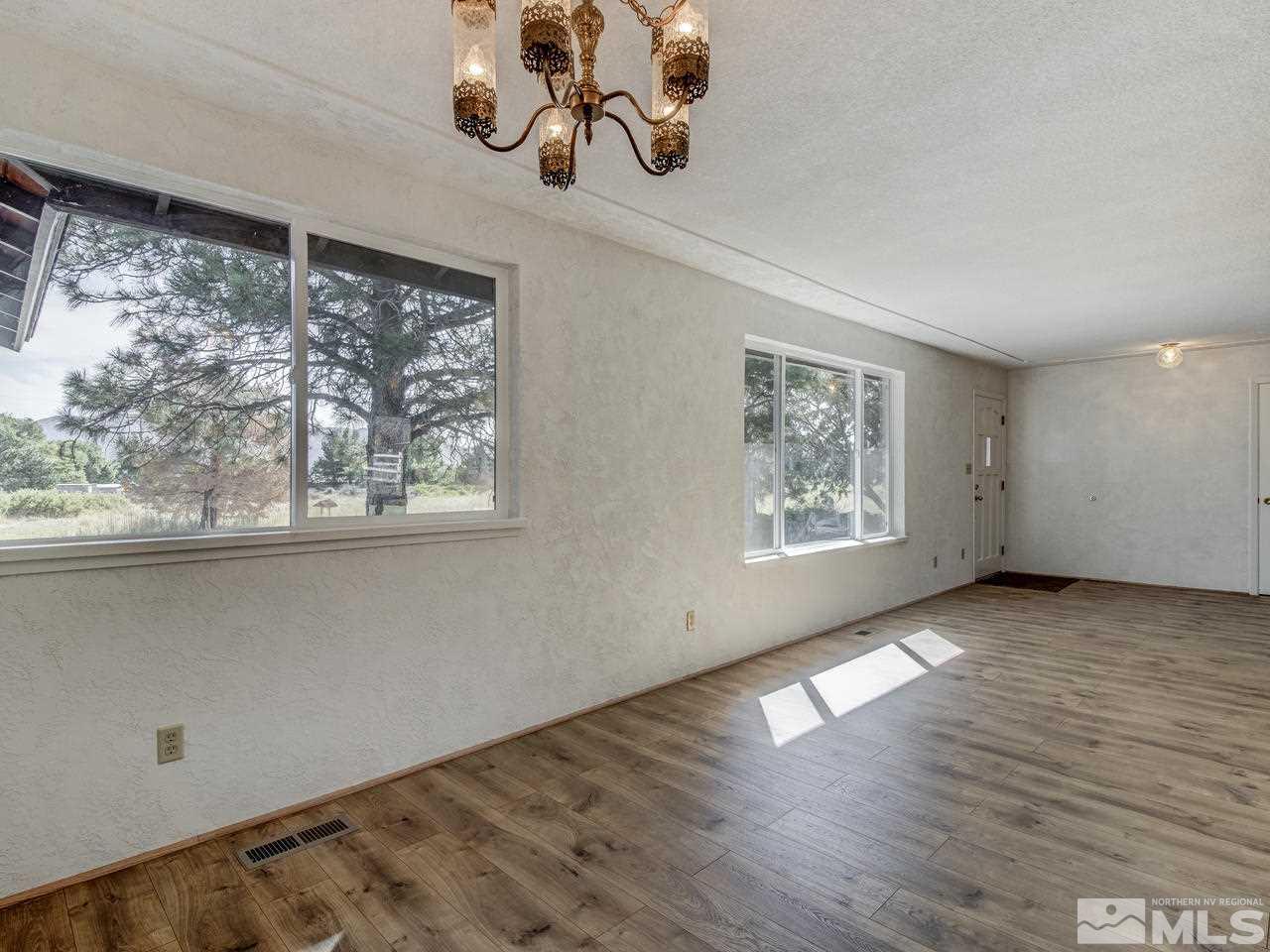 7465 Franktown Road Carson City, NV 89704 - Photo 7 of 25 a view of an empty room with wooden floor and a window