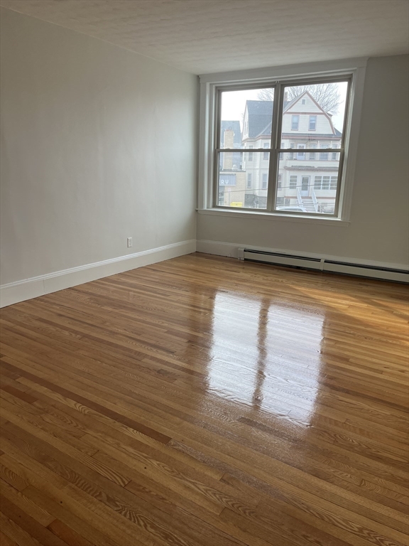 108 Bristol Road, Unit 1 Somerville, MA 02144 - Photo 8 of 24 a view of empty room with wooden floor and fan