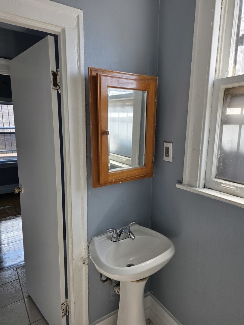 1853 East 79th Street, Unit 2 Chicago, IL 60649 - Photo 12 of 14 a bathroom with a sink toilet and mirror