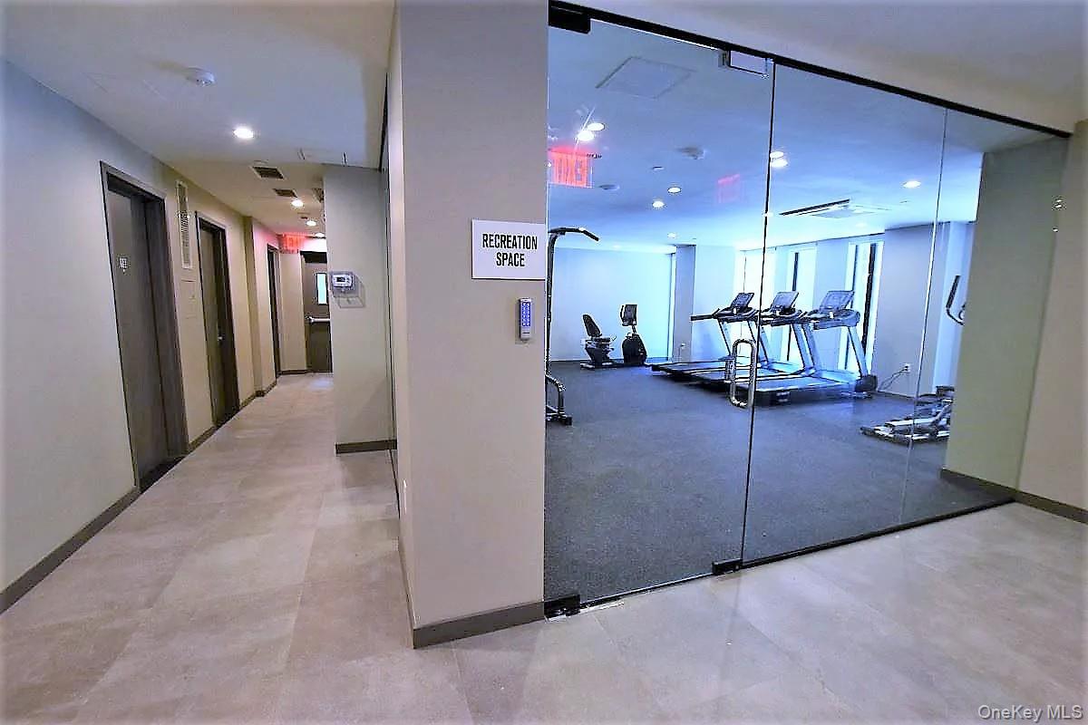 41-26 44th Street, Unit 3C Queens, NY 11104 - Photo 18 of 26 Workout area featuring elevator and recessed lighting