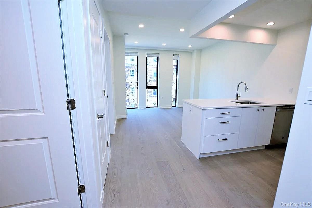 41-26 44th Street, Unit 3C Queens, NY 11104 - Photo 2 of 26 Kitchen featuring white cabinets, recessed lighting, light wood finished floors, a peninsula, and dishwasher