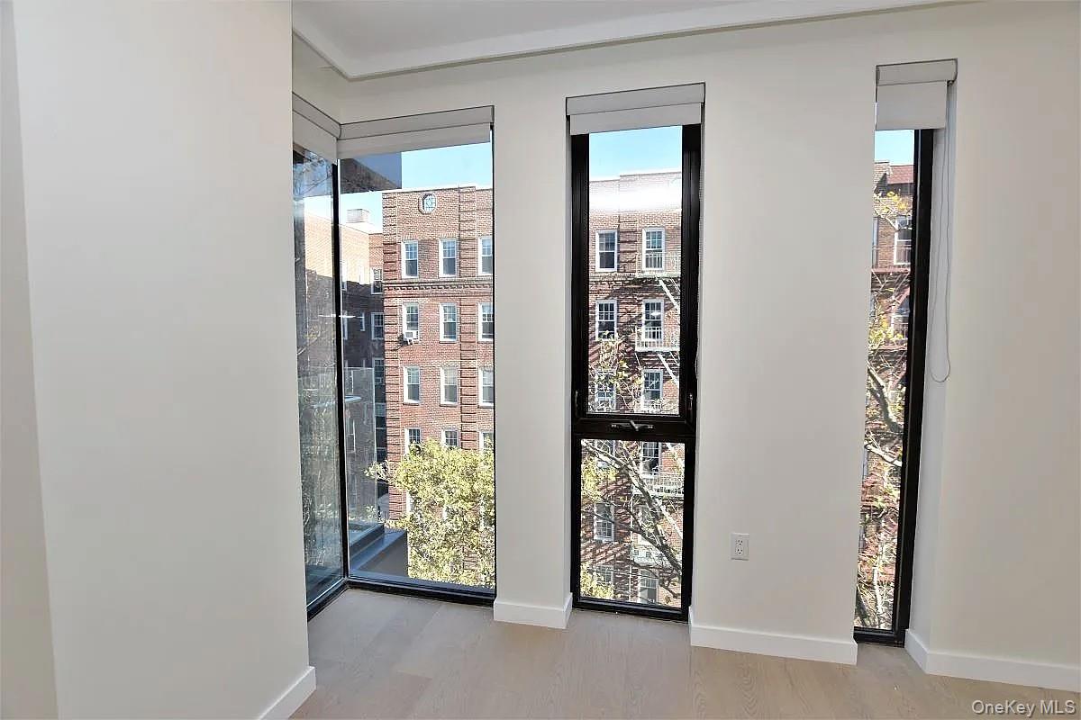 41-26 44th Street, Unit 3C Queens, NY 11104 - Photo 5 of 26 Empty room featuring a view of city and light wood-style floors