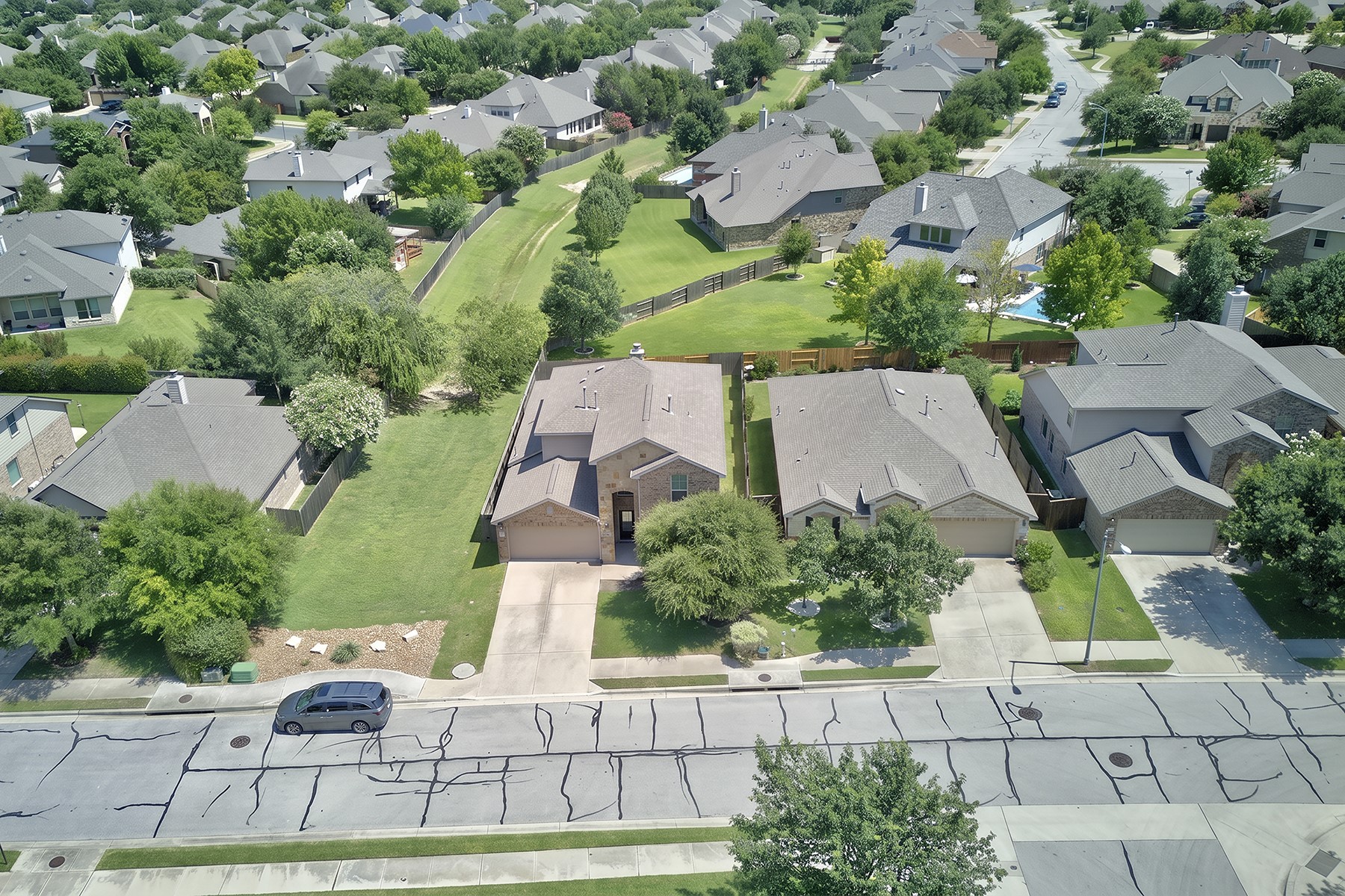 4601 Chestnut Meadows Bend Georgetown, TX 78626 - Photo 31 of 35 An aerial perspective reveals a quiet suburban street, showcasing a harmonious blend of manicured lawns and mature trees.