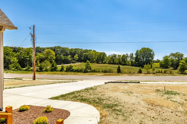 a kitchen with stainless steel appliances granite countertop a refrigerator a sink a stove and white cabinets