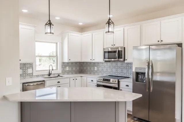 an empty room with wooden floor closet and windows