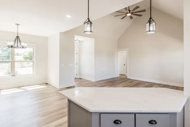 an empty room with wooden floor window and windows
