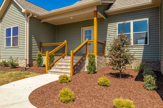 an empty room with wooden floor cabinet and windows