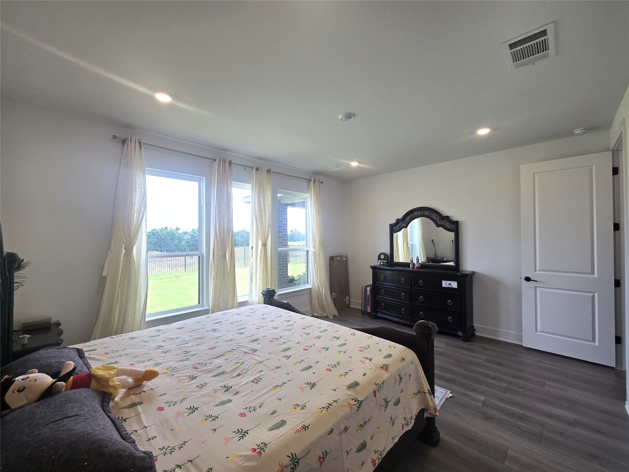 124 Ribera Drive Liberty Hill, TX 78642 - Photo 13 of 40 Well-lit sleeping quarters with rich flooring and a series of windows inviting natural light.