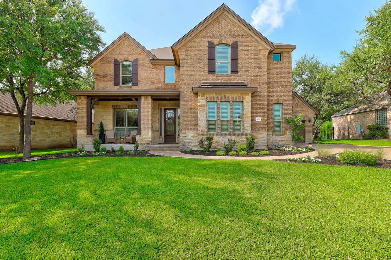 809 Prairie Dunes Drive Georgetown, TX 78628 - Photo 1 of 40 A well-manicured lawn leads to a charming brick and stone facade with a welcoming covered front porch.