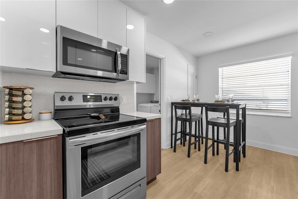 22718 Southwest 65th Terrace Boca Raton, FL 33428 - Photo 20 of 37 a kitchen with stainless steel appliances a stove a microwave sink and cabinets
