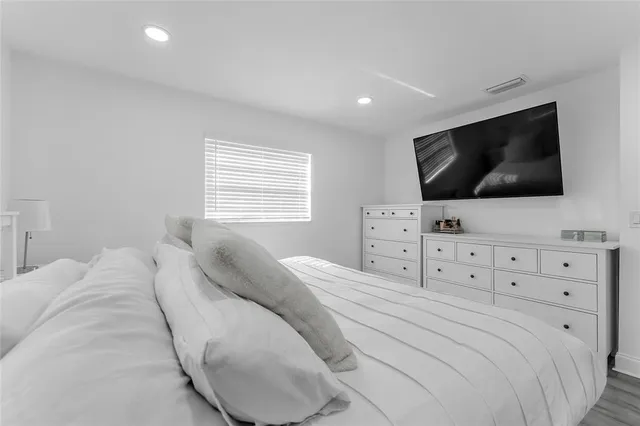 a bedroom with a large bed and a flat screen tv