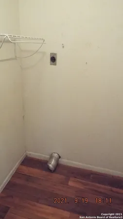 a view of a small space with wooden floor and a window