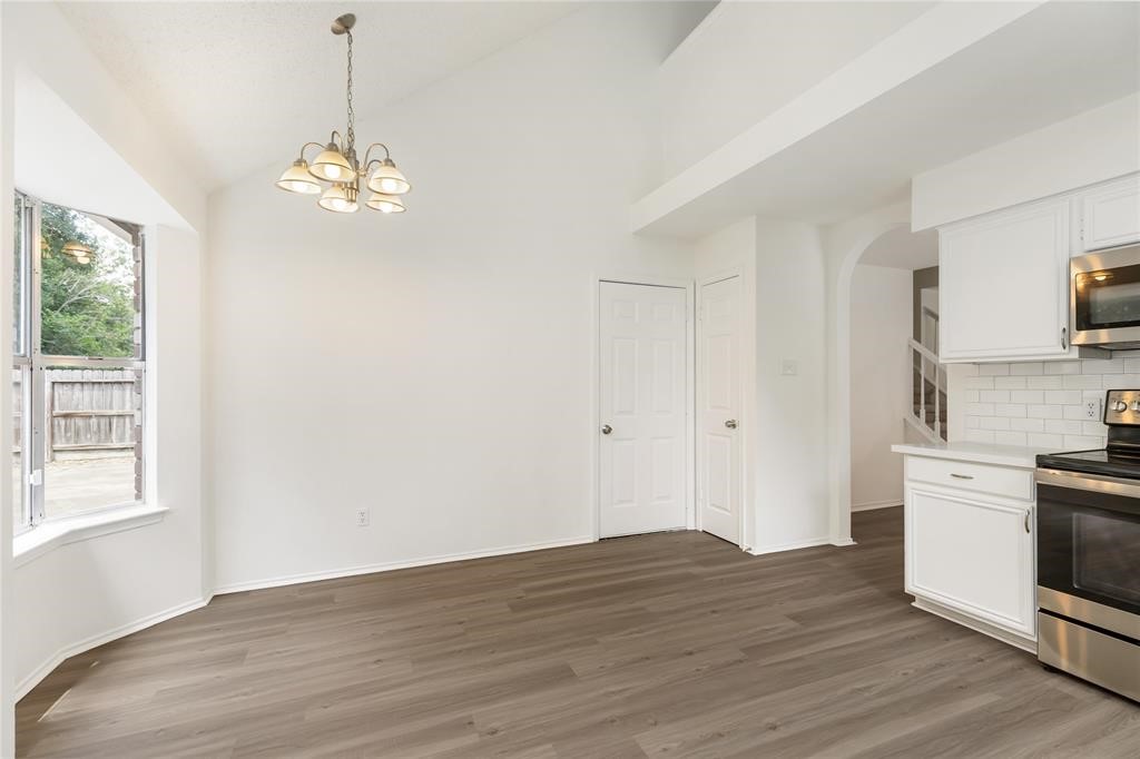 9410 Calwood Circle Spring, TX 77379 - Photo 11 of 34 a view of a kitchen with granite countertop stainless steel appliances a stove and wooden floor