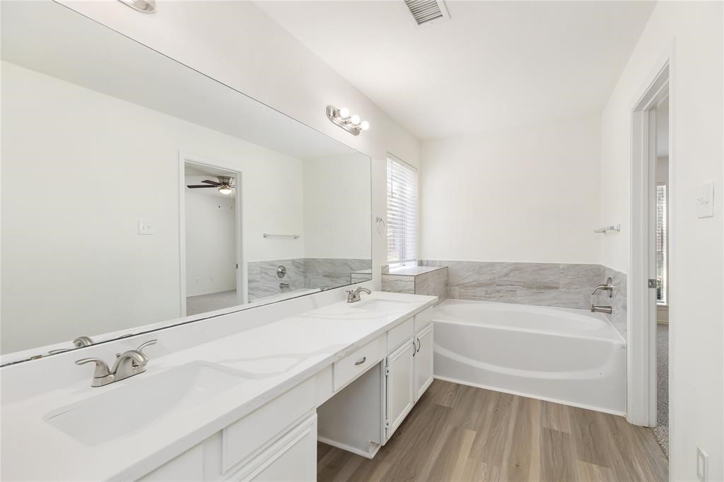 9410 Calwood Circle Spring, TX 77379 - Photo 14 of 34 a bathroom with a tub a sink and a mirror