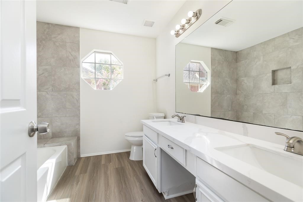 9410 Calwood Circle Spring, TX 77379 - Photo 21 of 34 a bathroom with a double vanity sink a mirror and a bathtub