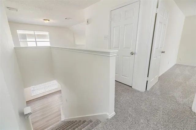 a backyard of a house with table and chairs and large trees