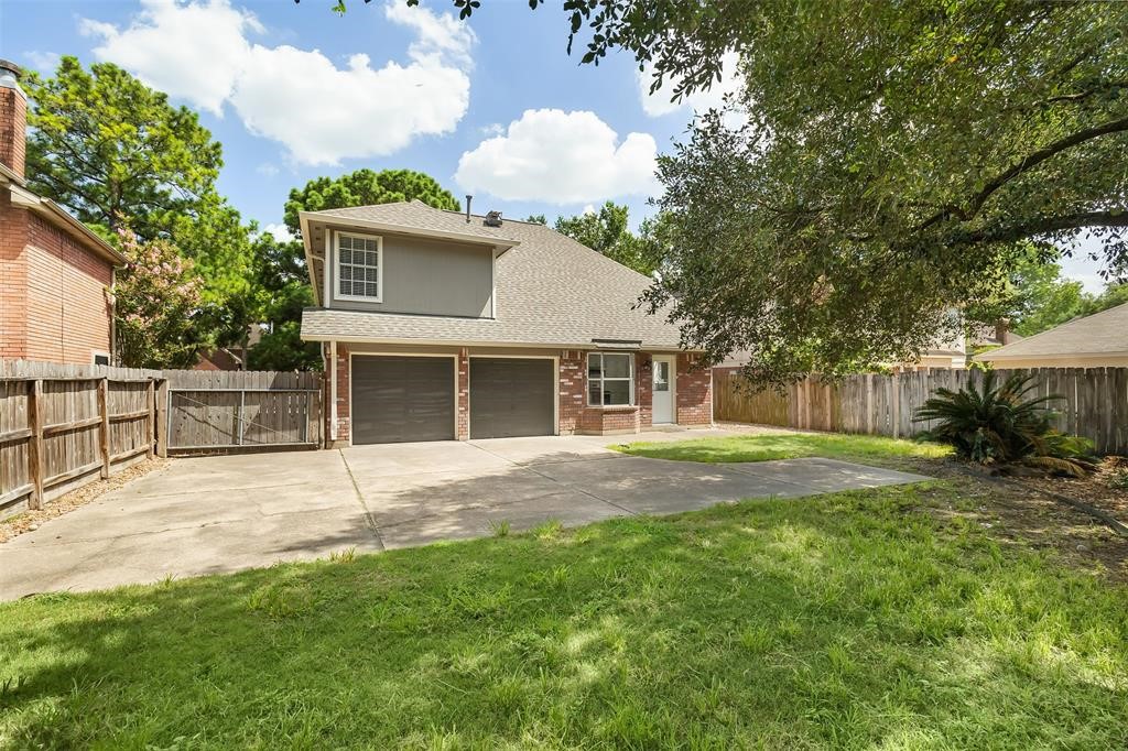 9410 Calwood Circle Spring, TX 77379 - Photo 34 of 34 a backyard of a house with table and chairs and large trees