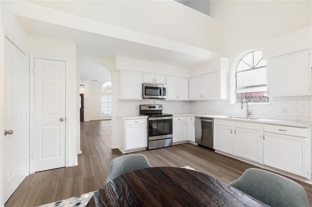 9410 Calwood Circle Spring, TX 77379 - Photo 8 of 34 a kitchen with granite countertop white cabinets and stainless steel appliances