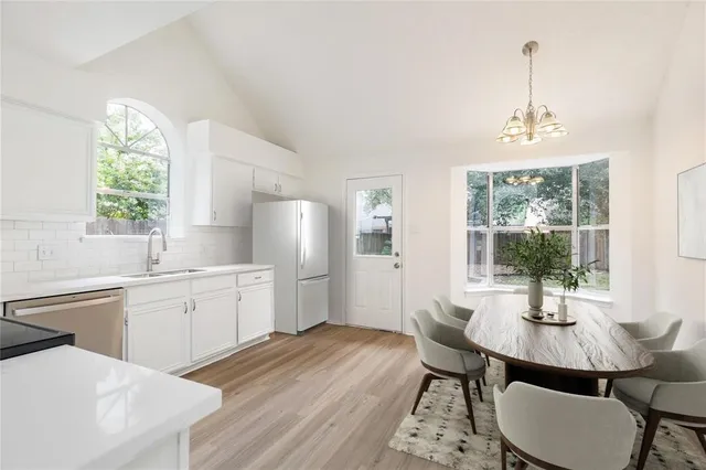 a view of a kitchen with granite countertop stainless steel appliances a stove and wooden floor