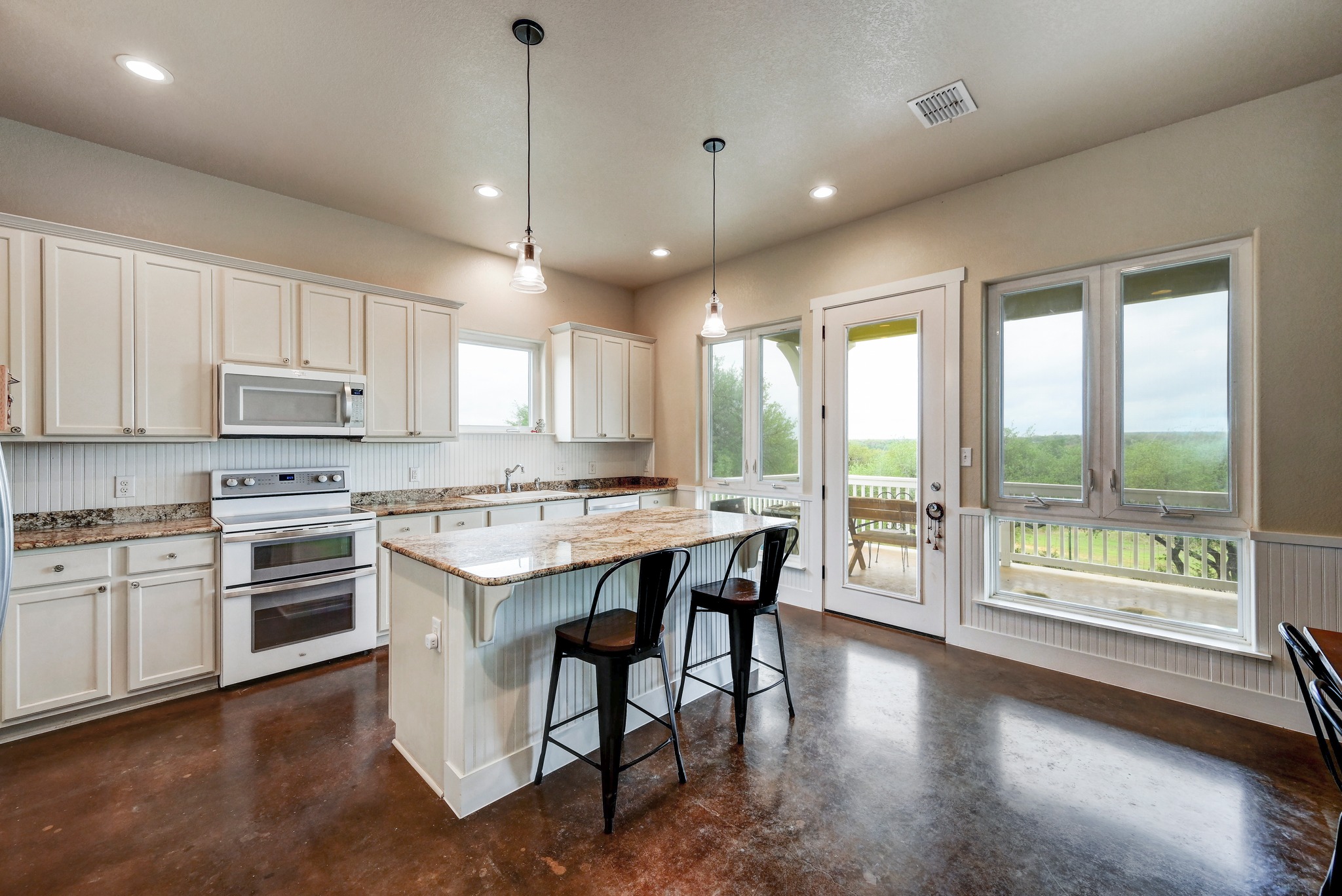 6350 Mt Sharp Road, Unit B Wimberley, TX 78676 - Photo 8 of 34 a kitchen with a stove a sink dishwasher a refrigerator and white cabinets with wooden floor