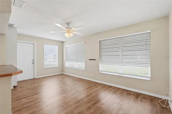 a view of an empty room with window and wooden floor