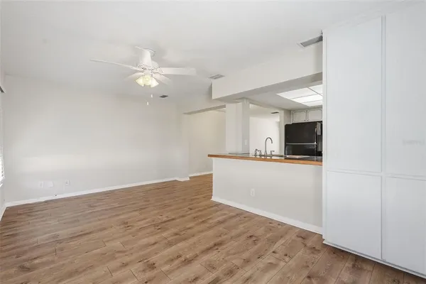 a living room with stainless steel appliances kitchen island a stove a refrigerator and a view of kitchen