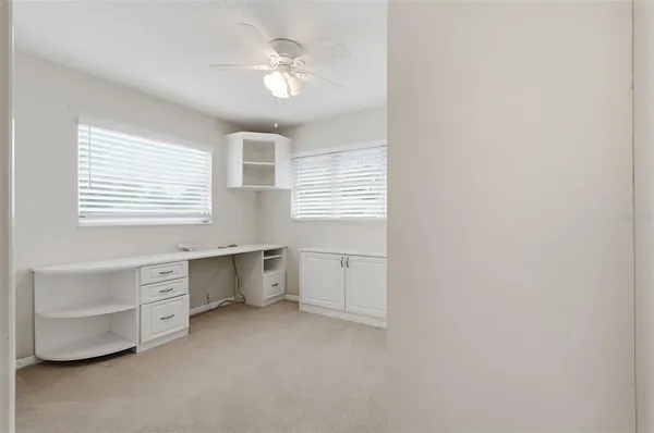 a view of an empty room with closet and a window