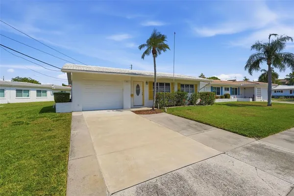 a front view of a house with a yard and potted plants