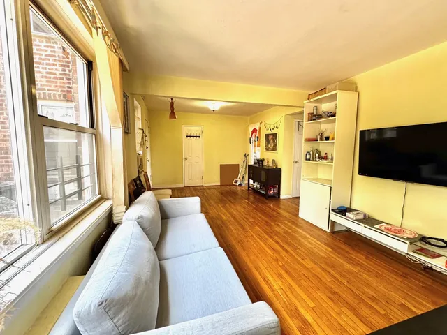 a bedroom with a large window and a flat screen tv
