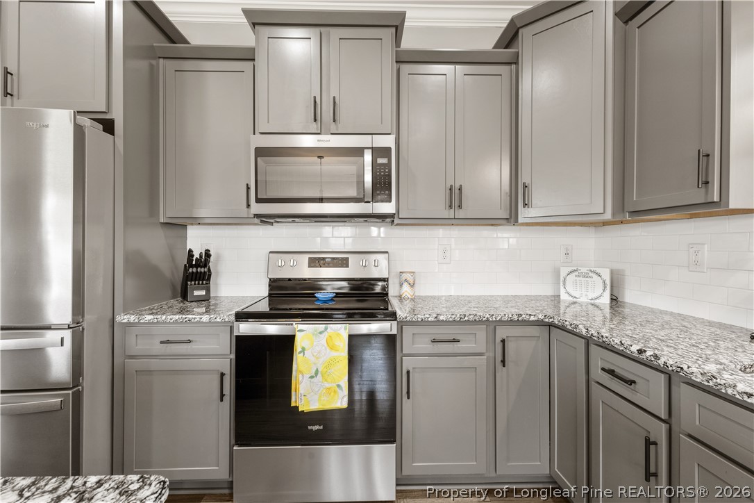 137 Minter School Road Sanford, NC 27332 - Photo 11 of 50 a kitchen with stainless steel appliances granite countertop a refrigerator sink and stove