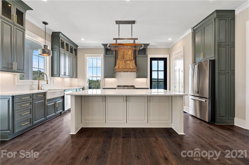 1198 Garvin Road York, SC 29745 - Photo 2 of 34 a kitchen with kitchen island granite countertop a refrigerator a sink dishwasher a stove and white cabinets with wooden floor